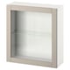 A white BESTÅ cabinet with a single glass door and a glass shelf inside, featuring a minimalist and modern design.