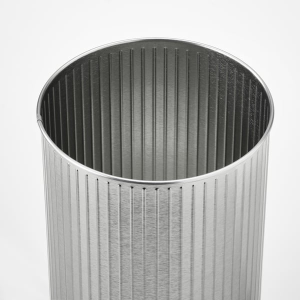 Silver cylindrical trash can with vertical grooves, sleek design, metallic finish.