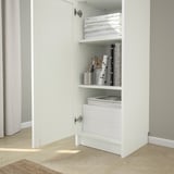 White BILLY bookcase with adjustable shelves; displays and stores books and items; anchored to wall, three shelves visible.
