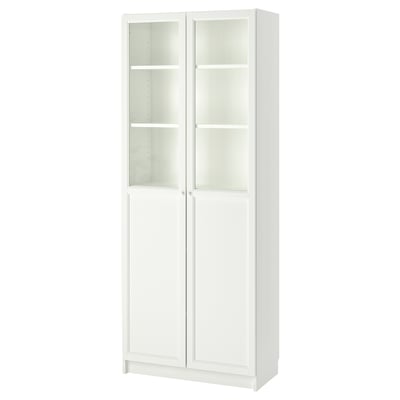 A BILLY bookcase in white, featuring glass doors and adjustable shelves, designed for versatile storage.