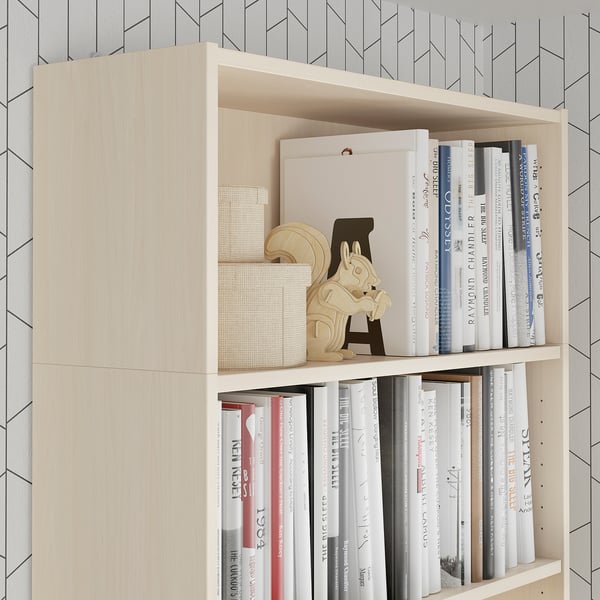 Light wood bookshelf with books, decorative items, and storage boxes. Anchored securely to the wall.