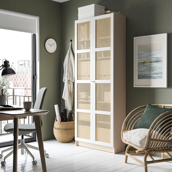 Home office with green walls, white floor, ikea BILLY bookcase with bamboo doors. Includes desk, chair, art, and clock.