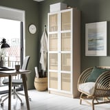 Home office with green walls, white floor, ikea BILLY bookcase with bamboo doors. Includes desk, chair, art, and clock.