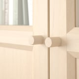Light wooden cabinet with adjustable hinges, natural grain texture.