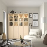 Minimalist living room with BILLY bookcase, decorative items, white couch, and checkerboard rug.