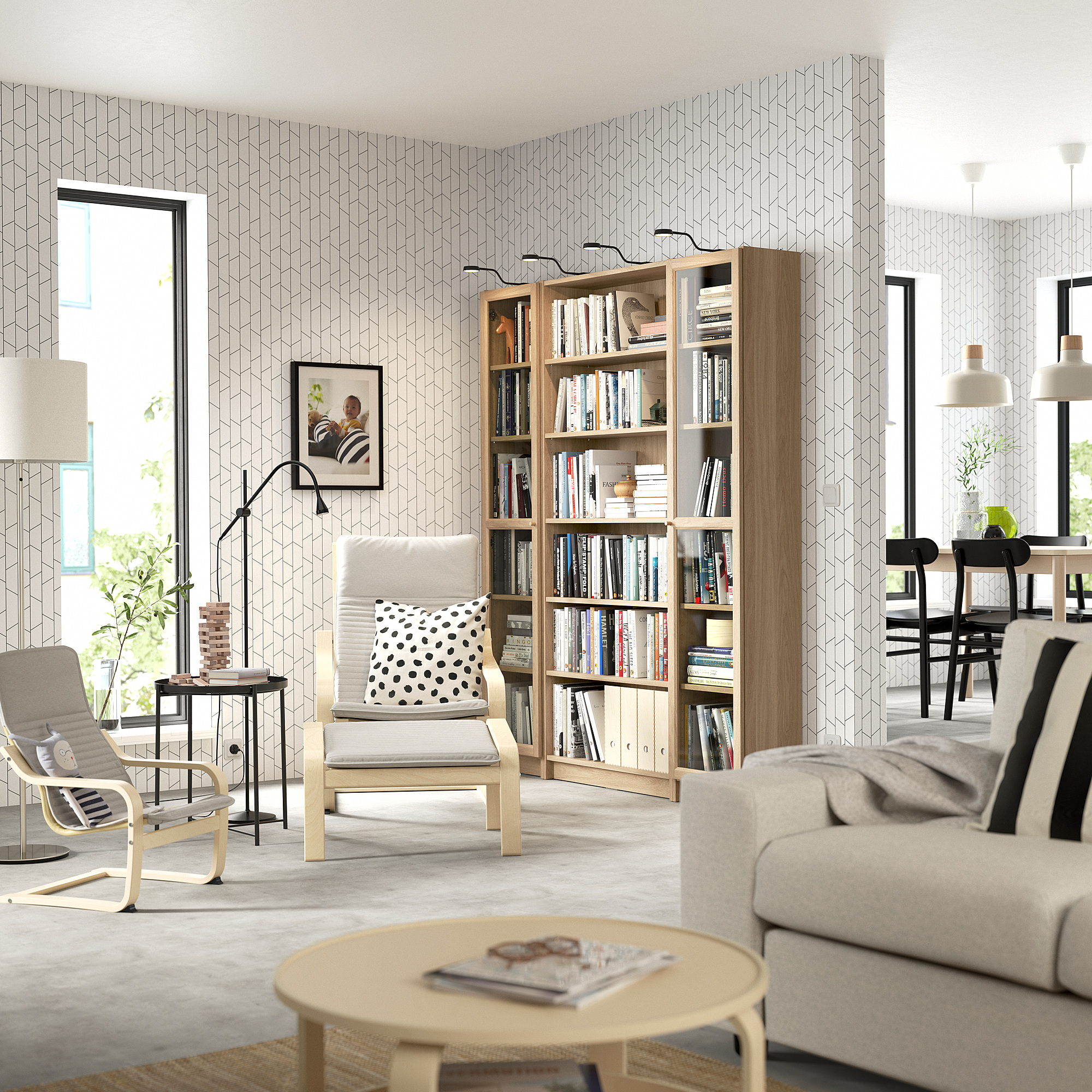 Modern living room with bookcase, sofa, armchairs, and lamp.