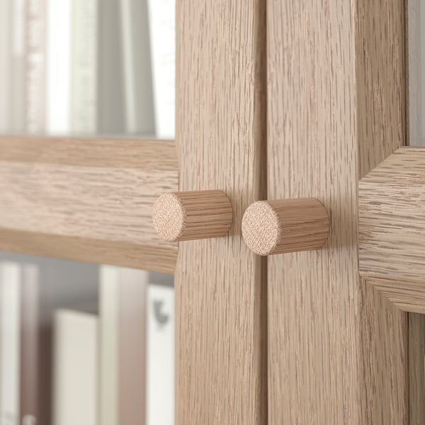 Wooden cabinet with round knobs, modern design.