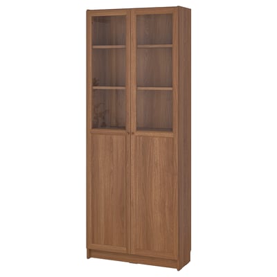 Wooden BILLY bookcase with glass doors, displaying items and hiding clutter.