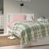 Green & off-white BISKOPSMÖSSA throw blanket, eco-friendly, on bed.