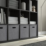 Black shelves with gray boxes and books; modern storage setup.