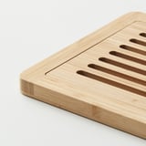 Wooden cutting board with grooves for collecting crumbs, made of bamboo.
