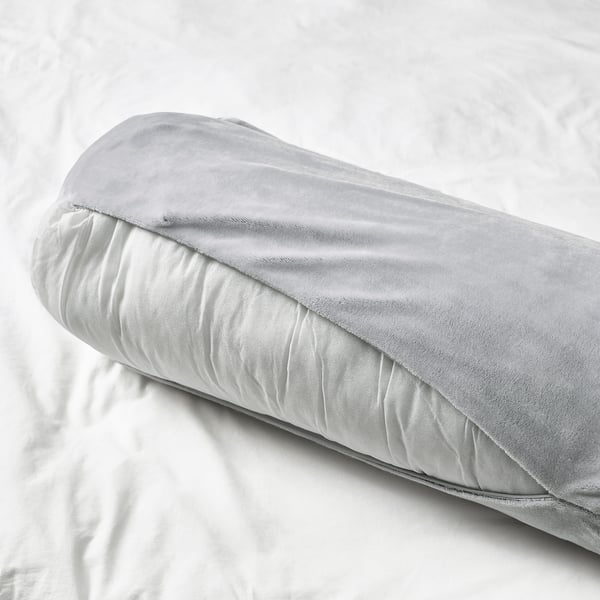 A soft, cylindrical cushion on a bed. Its versatile for supporting various body parts, perfect for kids from age 3.