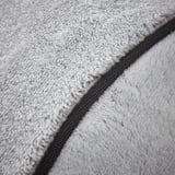 Dual-textured, gray cushion close-up. Soft, fluffy side and smooth, woven side evident, showcasing quality blend.