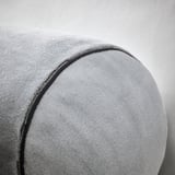 Soft grey cushion, circular shape, smooth fabric, detailed stitching, cozy and comfortable.