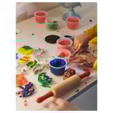Children playing with colorful dough and shaped cutters.