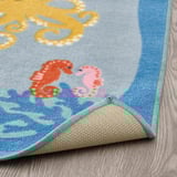 A colorful underwater-themed rug with sea creatures, featuring a non-slip backing for safety.
