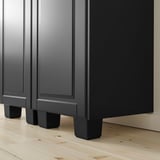 Black cabinet with adjustable feet for steady support on uneven floors.