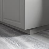 Gray kitchen cabinet plinths on wooden floor, creating a warm and traditional look, fitting metod series.