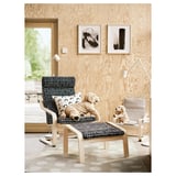 Living room with two wooden chairs, each with a stuffed animal. One has black-white, the other beige cushion. Abstract art on wooden wall, dotted rug.