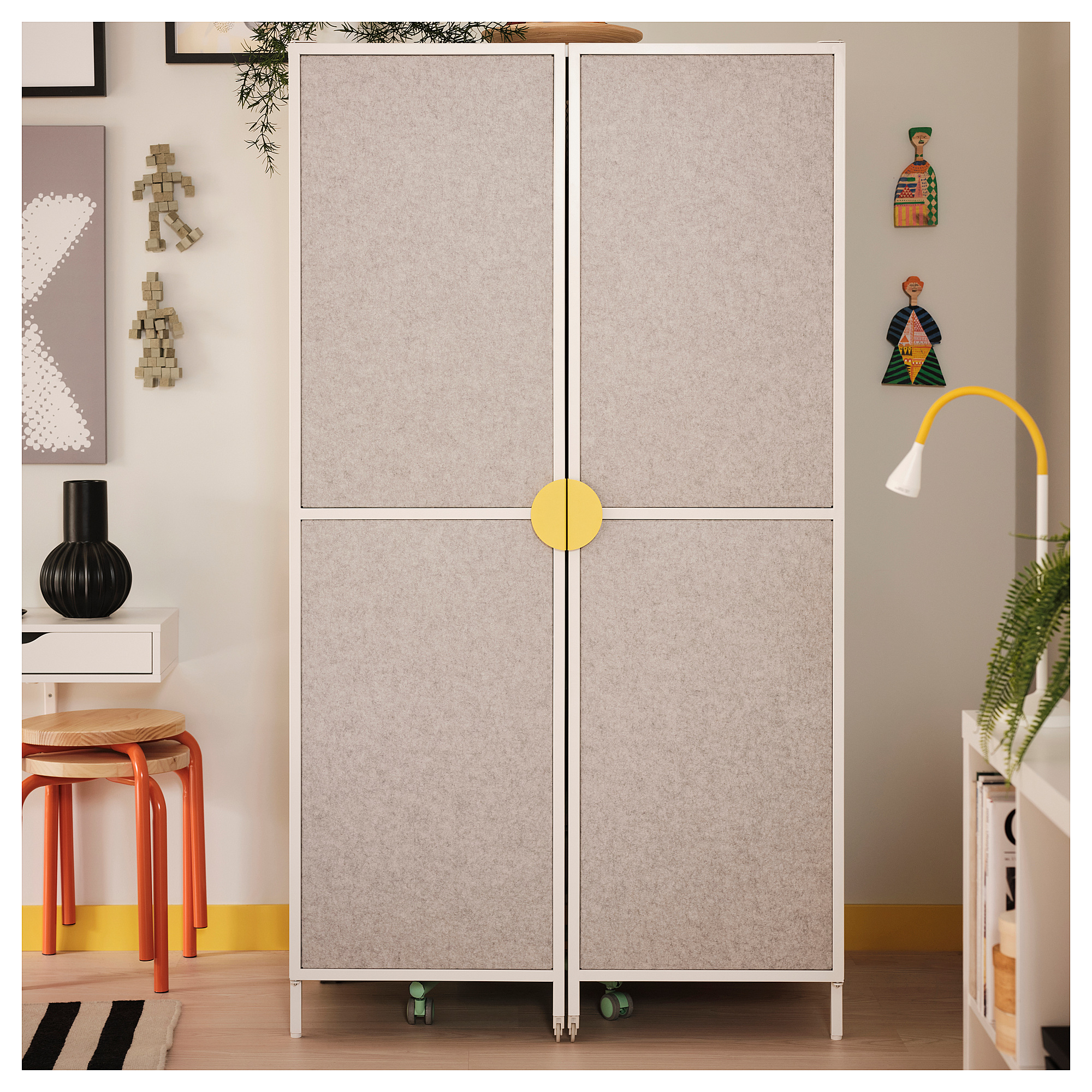 BRÄNNBOLL gaming station in room, large gray cabinet with yellow handles, wheels, surrounded by decor.