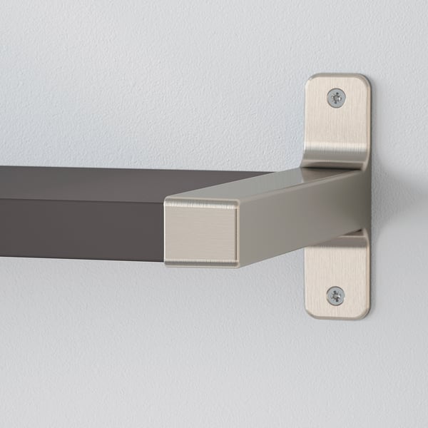 Close-up of modern, adjustable shelf bracket; sleek metal design, screws attached to wall.