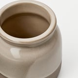 Rustic stoneware jar with smooth, glossy glaze. Round shape with wide opening. Natural, earthy color.