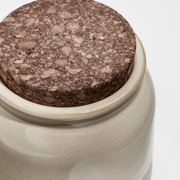 Close-up of a stoneware jar with a cork lid, showcasing its high-quality, textured surface and secure fit.