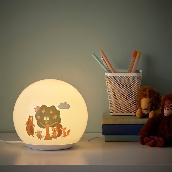BRUMMIG lamp decorates study desk with books, pencils, and toy.
