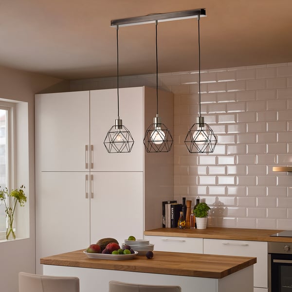 Modern kitchen with white BRUNSTA pendant lamps above wooden island, holding fruit bowl. Light, geometric design complements clean, minimalist decor.