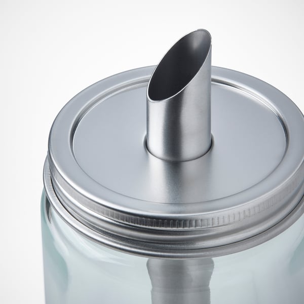 Cylindrical glass bottle with stainless steel cap and spout. Lid screws on securely, pours controlled amount.
