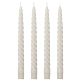 Four white spiral candles in a row. Made of paraffin and cotton. Tall, twisted design.