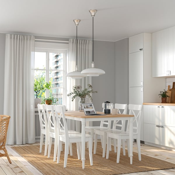 Modern white dining set with 6 chairs, rectangular table, soft lighting, and large window.