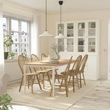 Modern dining set with 6 acacia chairs around a wooden table, vase centerpiece in a minimalist room with natural light.