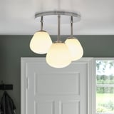 A ceiling light fixture with three spherical, opal glass shades and chrome details, providing soft, dimmable light.
