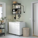 Small, beige DIMPA sorting bag near white kitchen counter, ideal for laundry or waste, with beige lid and handles.