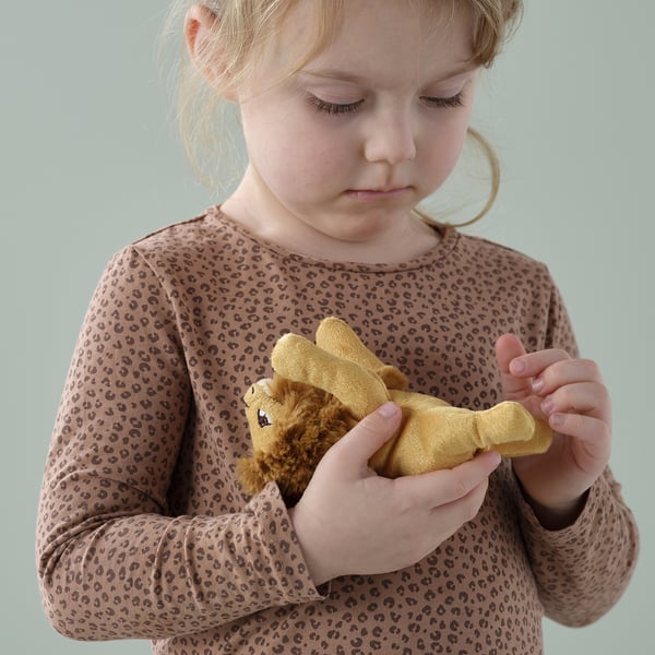 A child holding a small, soft lion toy, perfect for comfort and play.
