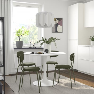 Modern dining area with white DOCKSTA table and green chairs, minimalist design, perfect for small spaces.