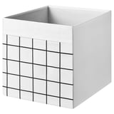 A white dróna fabric storage box with black grid patterns, featuring a square shape and integrated handles for easy access.