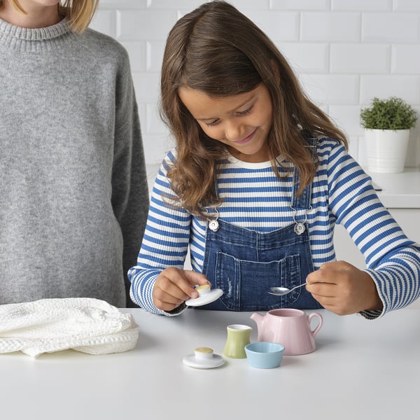 Girl plays with tea set on counter