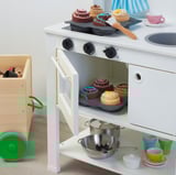 Toy kitchen play set with oven, pots, cups, and fake food.