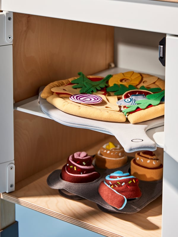 Toy kitchen shelf with colorful fabric oven mitts and plush buns.