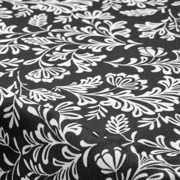 Black and white floral patterned chair pad. Intricate leaf designs on textured fabric.