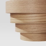 Modern, layered wood pendant lamp with natural finish.