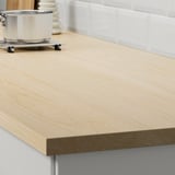 A sleek, light wood countertop, part of EKBACKEN, designed to be easily cleaned and long-lasting, showcasing its modern, minimalist style.