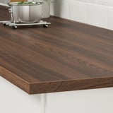 Glossy wooden kitchen counter with grain, metal trivet with durability.