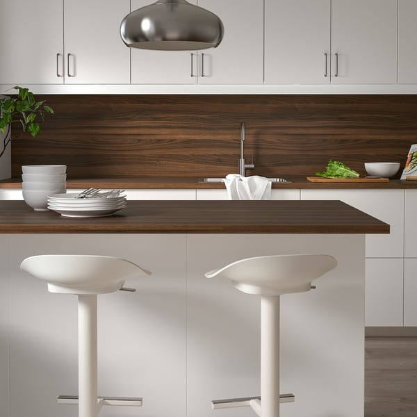 Modern kitchen with EKBACKEN countertop, white cabinets, and bar stools.