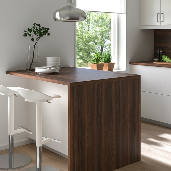 Modern kitchen featuring EKBACKEN walnut-colored countertop island with white stools, pendant light, and a window with greenery.