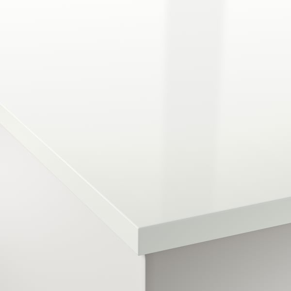 Close-up of smooth, white EKBACKEN laminate worktop corner, showcasing clean edges and glossy finish.