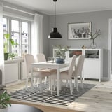 Minimalist EKEDALEN dining table with four chairs, striped rug, and sideboard in a cozy, contemporary dining space.