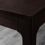 Dark wood table corner, smooth finish, sleek design, sturdy joint.